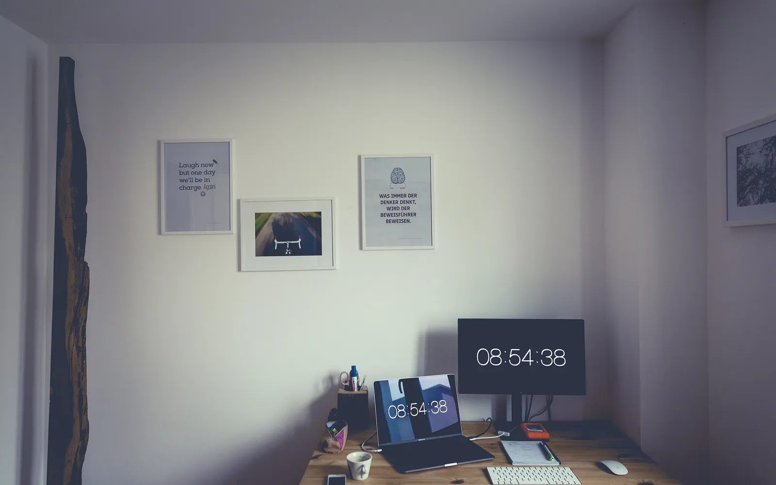 A home office desk with a laptop, keyboard and monitor
